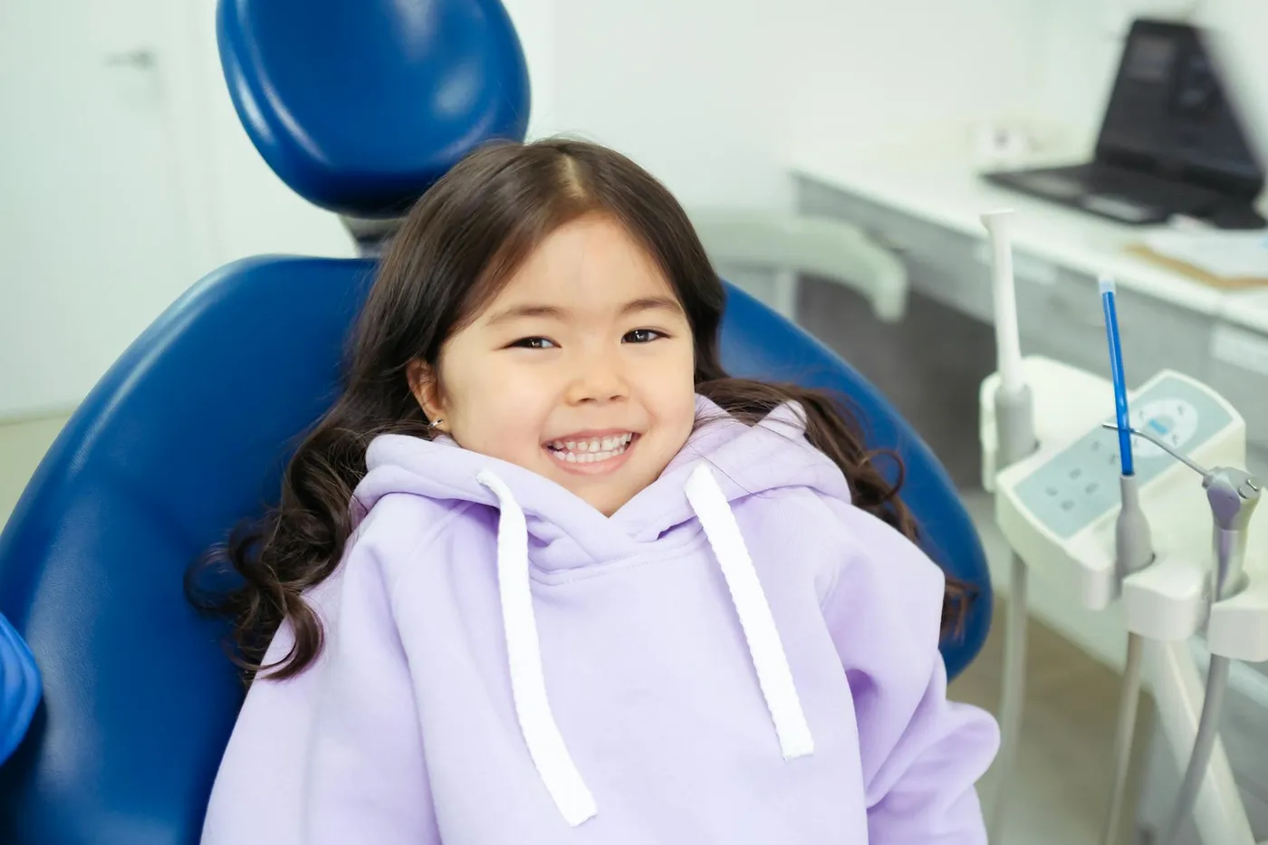 Cheerful child in a dental chair, ready for a dental checkup in a modern clinic.